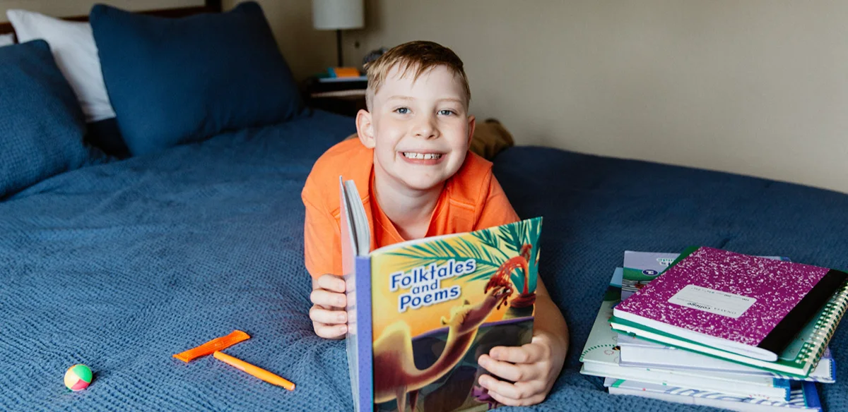 little boy smiling with book